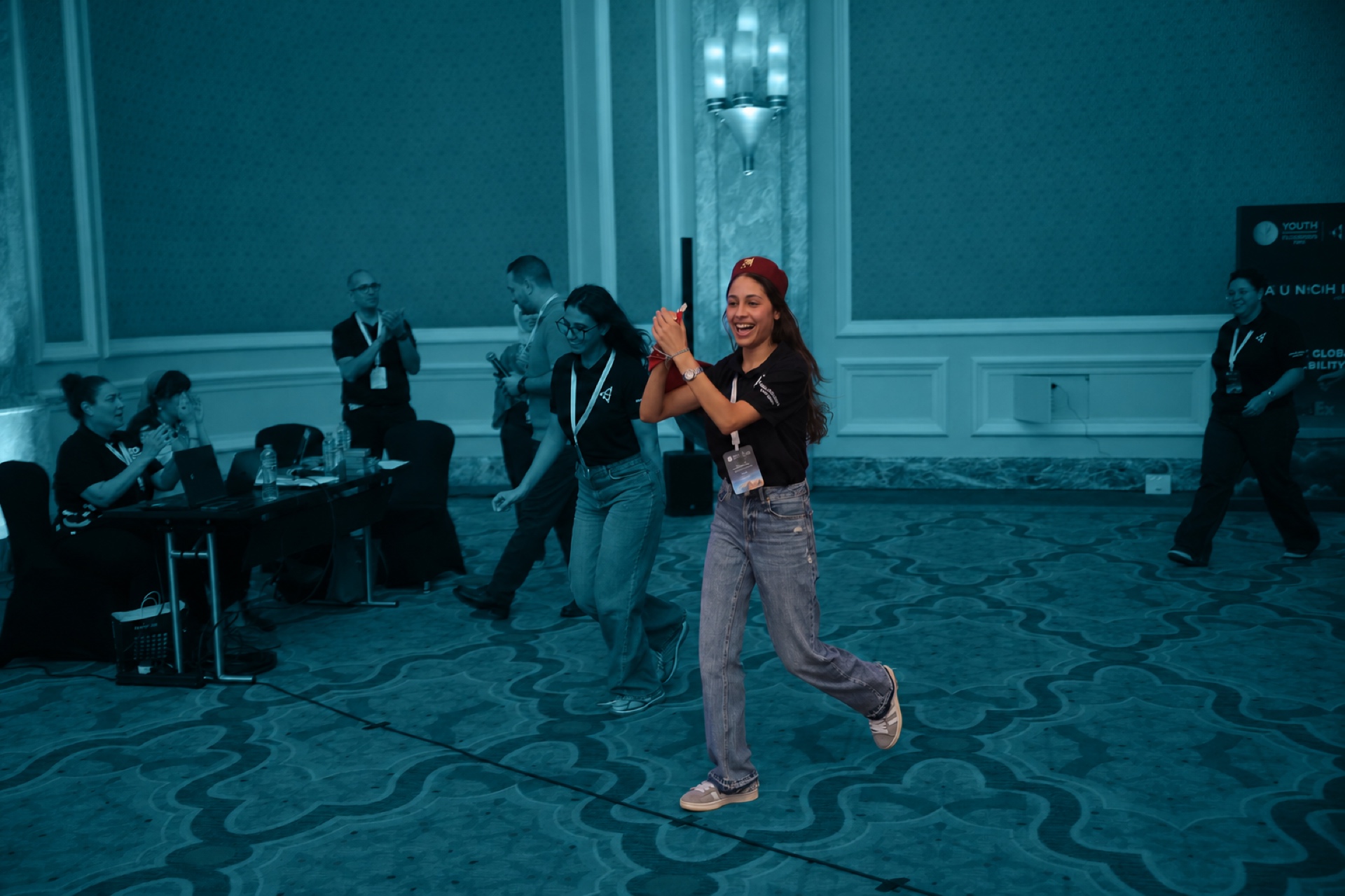 Two students celebrating and running through the hall