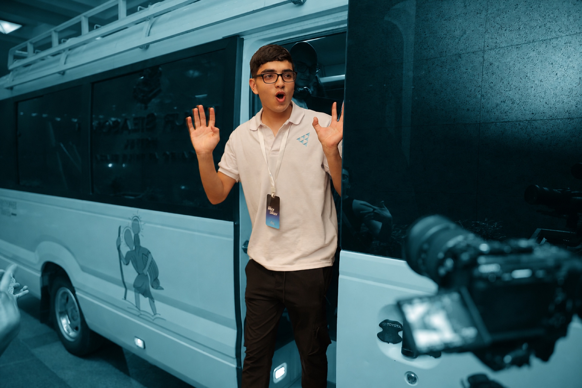 A student stepping off the bus at an INJAZ event, wide-eyed